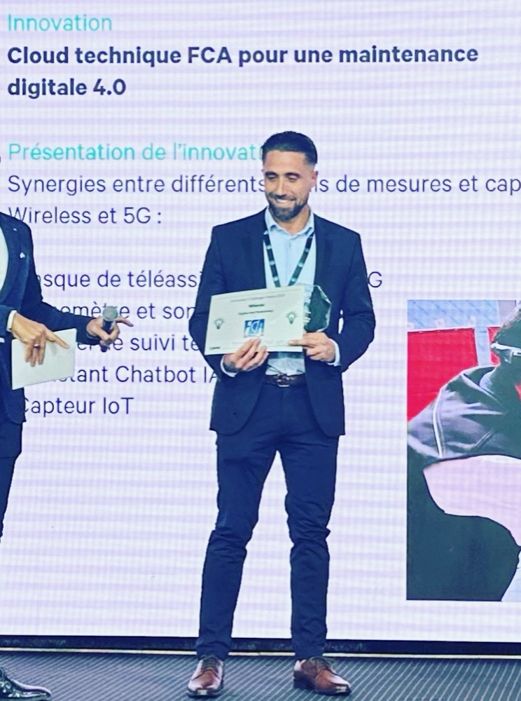 Anthony Ciccomancini sur scène, diplôme et trophée en main, devant la présentation du cloud technique FCA pour une maintenance digitale 4.0